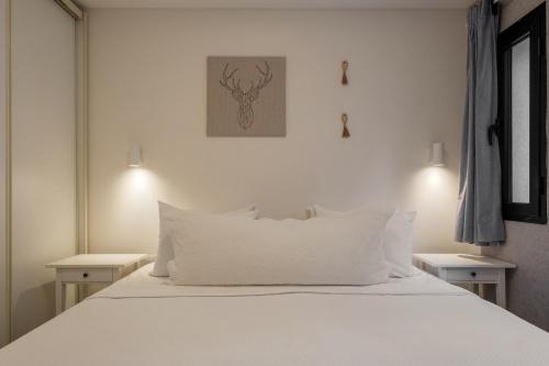 a bedroom with a white bed with white pillows at family apartment in Jerusalem