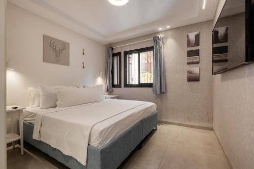 耶路撒冷的住宿－family apartment，卧室配有白色的床和窗户。