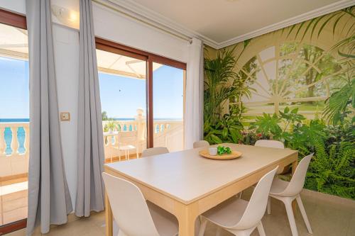 a dining room with a table and views of the ocean at Front Line Apartment Jakarta 2 in El Campello