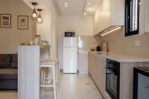 a kitchen with a white refrigerator and a table at family apartment in Jerusalem