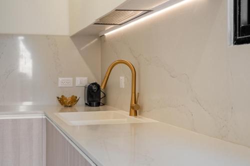 a kitchen sink with a gold faucet at family apartment in Jerusalem