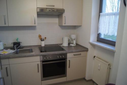 a small kitchen with a sink and a stove at Ferienwohnung Auszeit 511 in Bad Rodach