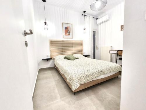 a white bedroom with a bed and a desk at Oditee Thessaloniki Spartis str in Thessaloniki