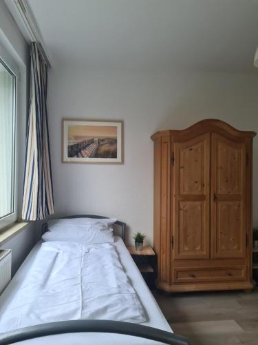 een slaapkamer met een bed en een houten kast bij B1- Appartements in Bochum
