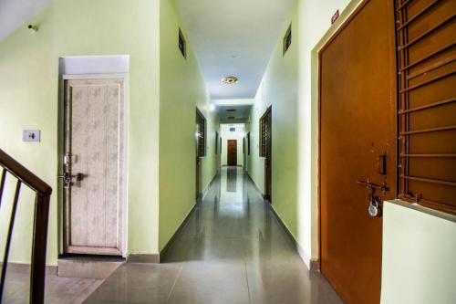 a hallway with green walls and a wooden door at OYO Flagship Adam's Bridge International Hotel in Patna