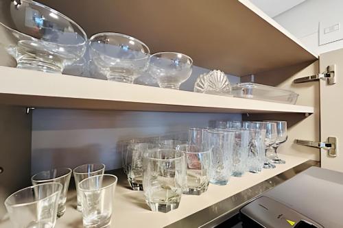 una fila de vasos en estanterías en una cocina en Solar Tambaú Apartamentos Luxuosos, en João Pessoa