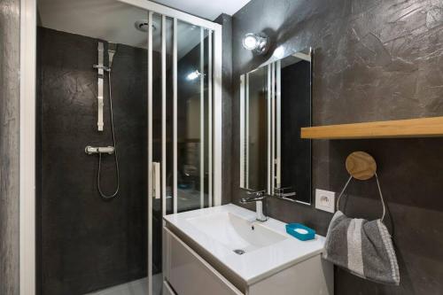 une salle de bain avec un lavabo blanc et une douche dans l'établissement Une escale de charme au port de Dinan ..., à Dinan