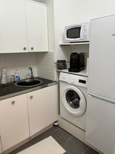 een keuken met een wasmachine en een magnetron bij L avenir in Clichy