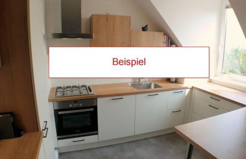 een keuken met witte kasten en een fornuis met oven bij Chefs Gästezimmer in Neupotz