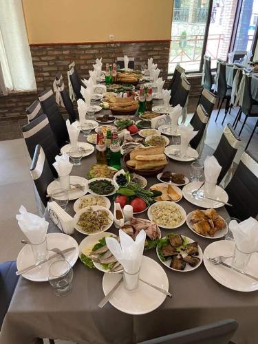 una mesa larga con platos de comida. en Vachnadziani wine resort, en Gurjaani