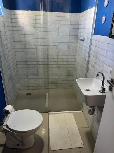 łazienka z toaletą i umywalką w obiekcie St. Benoit suites e hostel w mieście Presidente Prudente