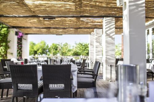a restaurant with tables and chairs on a deck at ROBINSON QUINTA DA RIA - All Inclusive in Vila Nova de Cacela