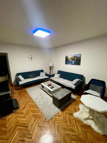 a living room with a blue couch and a table at Apartman Silver in Jajce
