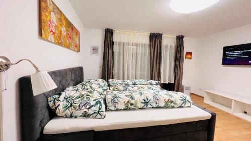 een slaapkamer met een bank, een bed en een raam bij T&T Panorama Apartment in Blaustein