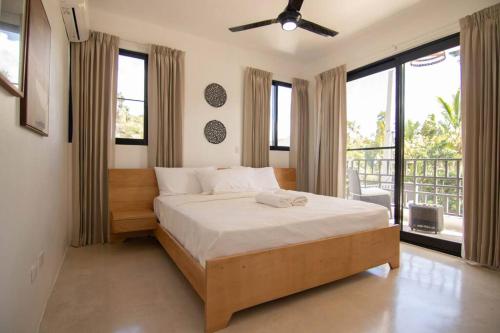 a bedroom with a large bed and large windows at Casita Bower in Inoa