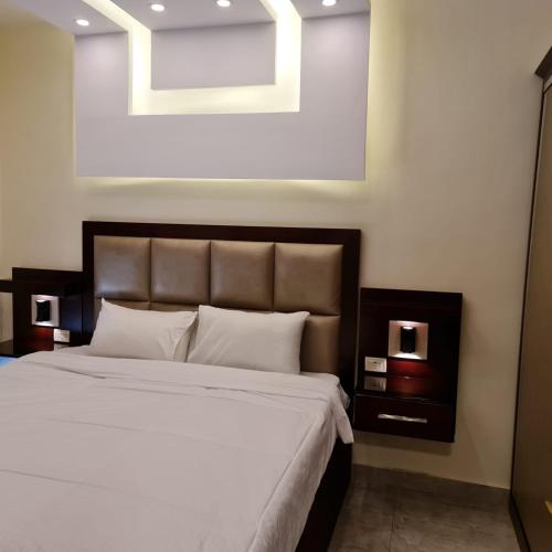 a bedroom with a large bed with white sheets at 30th apartment in Amman