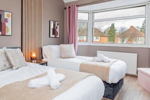 a hotel room with two beds and a window at Brays Home for families, contractors and professionals in Birmingham