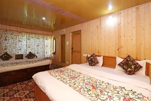 a bedroom with two beds and wooden walls at Hotel Bright Palace in Pahalgām