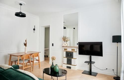 un salon avec un canapé vert et une table dans l'établissement Luxury apartment 1min from Eiffel Tower, à Paris