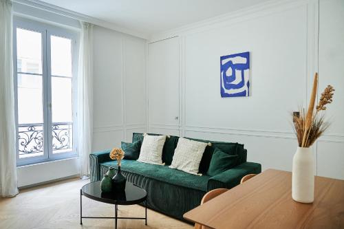 un salon avec un canapé vert et une table dans l'établissement Luxury apartment 1min from Eiffel Tower, à Paris