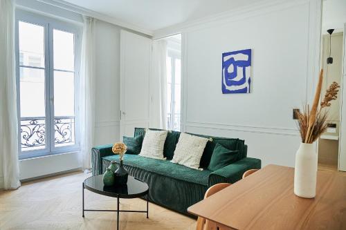 salon z zieloną kanapą i stołem w obiekcie Luxury apartment 1min from Eiffel Tower w Paryżu