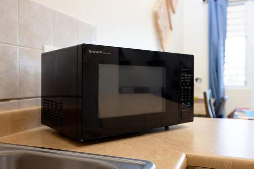 a microwave sitting on top of a kitchen counter at Golden Dream Villas & Studio A/B Pool View in Isabela