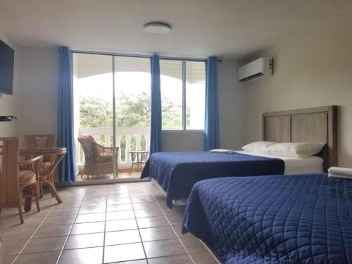 um quarto de hotel com duas camas e uma varanda em Golden Dream Villas & Studio A/B Pool View em Isabela