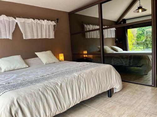 1 dormitorio con 1 cama grande y espejo grande en La Maisonnette d'Hermival à 2 min de Lisieux - Jardin - Pkg - Wifi en Hermival-les-Vaux