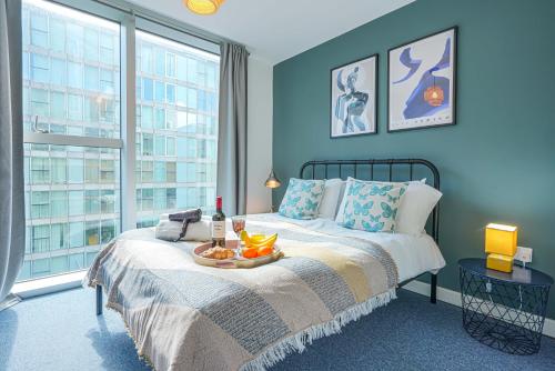 een slaapkamer met een bed en een dienblad met fruit erop bij City Centre Apartment with Free Parking, Super-Fast Wifi and Smart TV with Netflix by Yoko Property in Milton Keynes