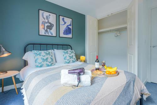 een blauwe slaapkamer met een bed en een dienblad met fruit erop bij City Centre Apartment with Free Parking, Super-Fast Wifi and Smart TV with Netflix by Yoko Property in Milton Keynes