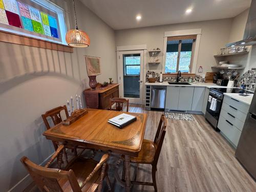 a kitchen with a wooden table and chairs in it at Cowichan Valley Guest Cottage in Ladysmith
