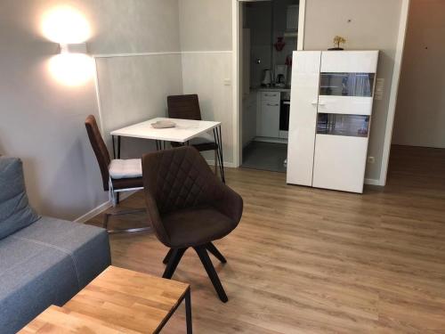 ein Wohnzimmer mit einem Sofa, einem Tisch und einem Kühlschrank in der Unterkunft Ferienwohnung Parkblick 712 in Bad Rodach