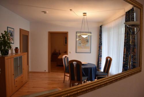a dining room with a table and chairs in a mirror at Ferienwohnung Kurringblick 938 in Bad Rodach
