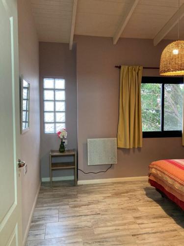 a bedroom with a bed and a table and windows at 1991HospedajeD3 in Ensenada