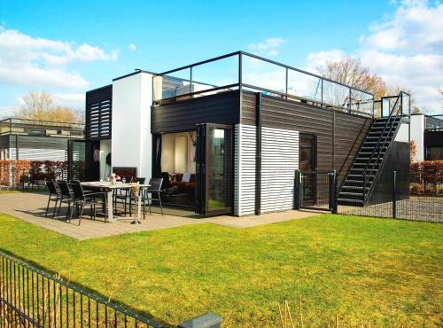 a glass house with a table and a dining room at Royale Cube mit Dachterrasse Meerblick und Strand in Hulshorst