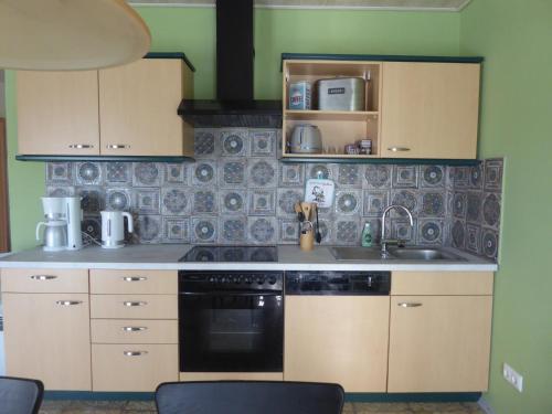 a kitchen with a sink and a stove at Afrika in Eggesin