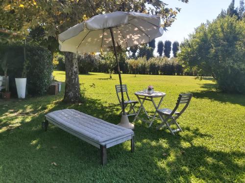 mesa y banco con sombrilla, mesa y sillas en Villa Fioccomare, en Camaiore