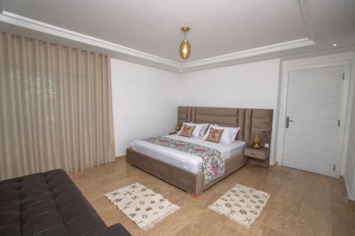 a bedroom with a bed and a couch at Villa Meriem, Fès in Oulad Tayeb