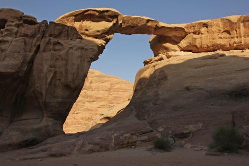 an arch in a rock formation in the desert at Wadi Rum Faris in Wadi Rum