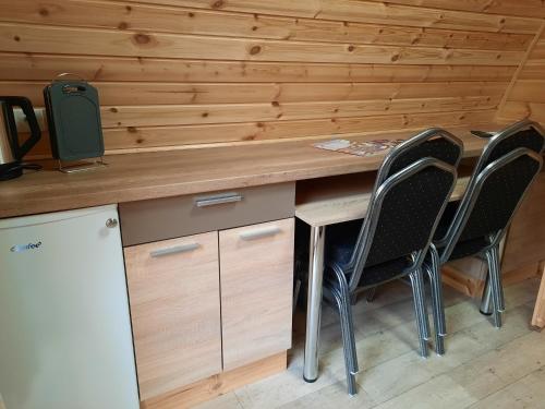 a desk with three chairs and a computer on it at 43 Camping Pod in Silberstedt