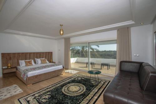 a bedroom with a bed and a couch at Villa Meriem, Fès in Oulad Tayeb