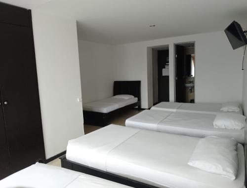 sypialnia z 2 łóżkami i kanapą w obiekcie Hotel Bolivariano AV w mieście Ibagué
