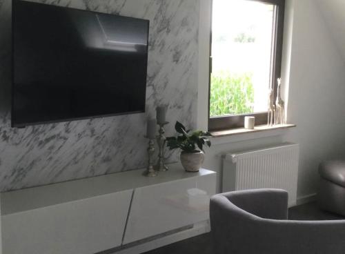salon z telewizorem z płaskim ekranem na ścianie w obiekcie Bei Getrost to Huus w mieście Bad Oeynhausen