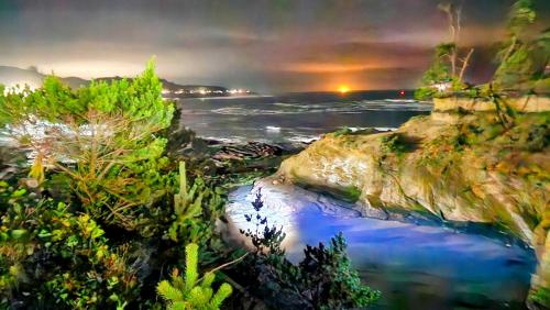 a view of a body of water at night at Inn at Arch Rock in Depoe Bay