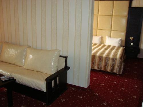 a hotel room with a bed and a couch at Hotel Villa Ofir in Sandanski