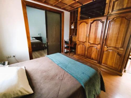 a bedroom with a bed with a wooden wall at Hotel G&G in Cuenca