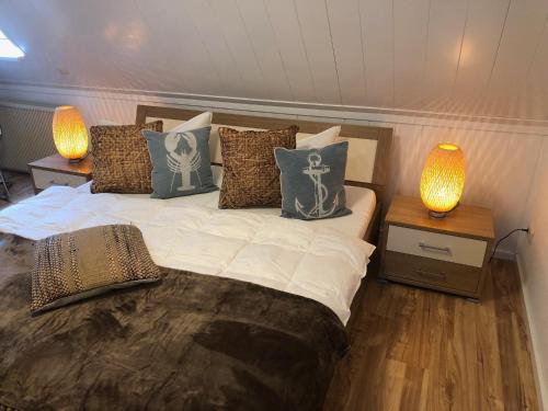 1 dormitorio con 1 cama con almohadas y 2 lámparas en Ferienhaus Boddenblick mit Sauna, en Pruchten