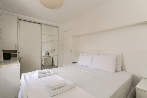 a white bedroom with a large bed with white pillows at 200m do Beiramar Shopping #CA44D in Florianópolis