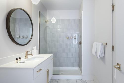 a white bathroom with a sink and a shower at Outrider 107 by AvantStay Perfect Nash Location in Nashville