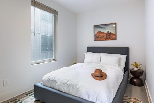 a bedroom with a bed with a cowboy hat on it at Outrider 107 by AvantStay Perfect Nash Location in Nashville